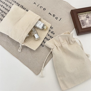 Detailed macro view of cream canvas drawstring pouch storing cosmetic glass bottles