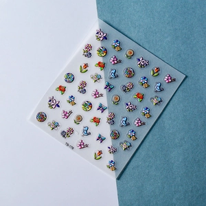 Detail view of 5D embossed nail stickers featuring flowers, bluebirds, and art motifs