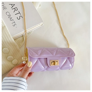 Detailed close-up of light purple quilted cylinder bag with gold chain and pearl accents