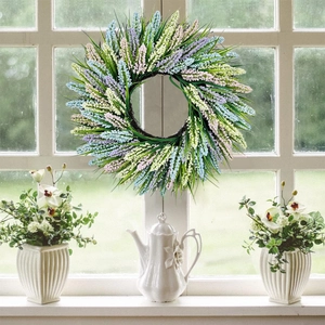 Pastel lavender and wildflower wreath on a white window frame for spring home decoration