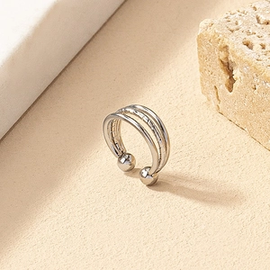 Detail view of silver multi-layer non-piercing nose clip with spherical ends on stone background