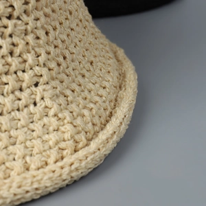 Close-up of the beige hollow woven pattern and thick yarn texture of the bucket hat