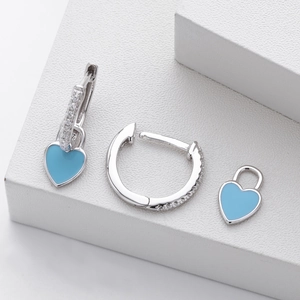 Macro detail of 925 silver hoop earrings with blue enamel hearts and zircon paving