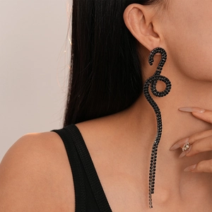 Close-up of twisted snake earrings with black rhinestones and long tassel on a model