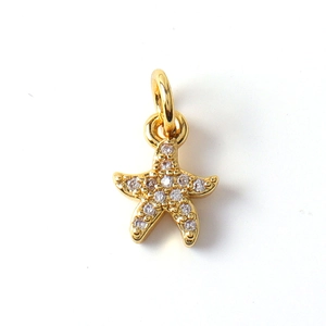 Macro shot of gold-plated starfish pendant with clear cubic zirconia inlay and top loop