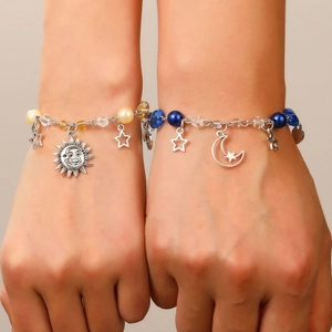 Detail of sun and moon charm bracelets with blue and beige beads for best friends
