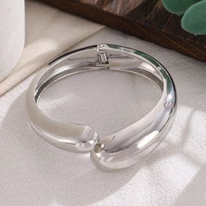 Dettaglio del bracciale minimalista argento con finitura lucida a specchio e design a goccia