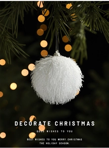Close-up of white fluffy Christmas ball with glitter and festive bokeh background