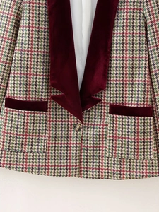 Macro detail of houndstooth wool blazer featuring premium burgundy velvet lapels and texture