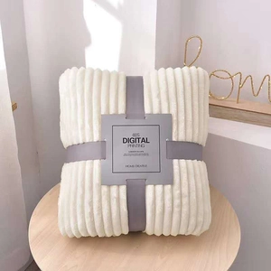 Folded cream flannel throw blanket with vertical ribbed texture and premium grey gift wrap