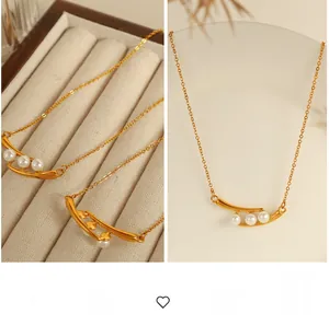 Détail d'un collier en or avec trois perles blanches sur un pendentif en barre incurvée