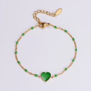 Detail of 18k gold plated stainless steel bracelet with green beads and heart charm