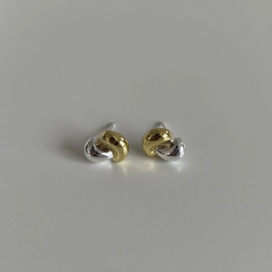 Close-up of two-tone knotted stud earrings in gold and silver finish with S925 silver pins