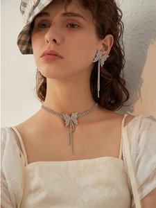 Detail of butterfly fringe necklace and earring set with shimmering white rhinestones
