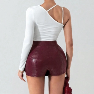 Back view of burgundy crocodile texture leather shorts and white one-shoulder top