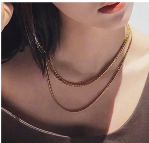 Close-up of double layer gold-plated flat snake chain necklace on model's neck