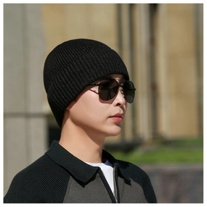Detailed ribbed texture of a black winter knit beanie worn with stylish sunglasses