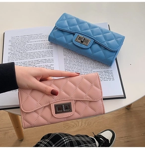 Close-up of quilted pattern and vintage metal twist lock on pink and blue long wallets