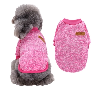 Detail of rose pink knitted pet sweater with Classic leather label on a toy poodle