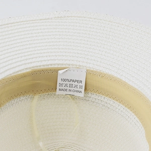 Detail of the 100% paper straw hat inner band and white care label with origin text