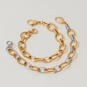 Detail of twisted cable chain bracelets in gold and two-tone silver finishes