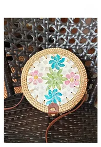 Detail of round rattan bag with colorful shell flower mosaic and brown leather strap