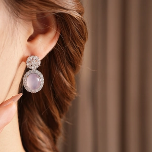 Détail de boucles d'oreilles vintage en argent avec calcédoine rose et fleur de zircon