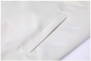 Macro detail of side pocket stitching and smooth matte fabric on a white casual jacket