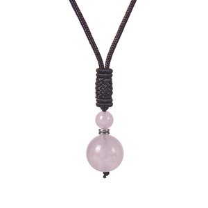Vue macro du pendentif en cristal rose rond de 16 mm sur cordon noir tressé