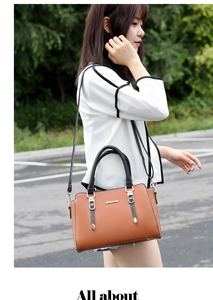Brown PU leather handbag with black handles shown in an outdoor lifestyle setting