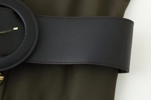 Détail d'une robe midi vert olive avec une large ceinture en cuir marron et boucle dorée