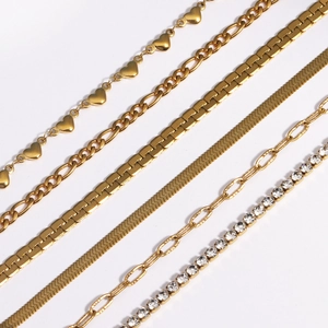 Gros plan sur des chaînes dorées styles cœur, figaro, serpent et trombone élégants