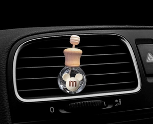 Detailed view of Mickey-shaped car perfume bottle on black air vent grille