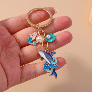 Détail du porte-clés baleine et sirène avec émail bleu et perles blanches