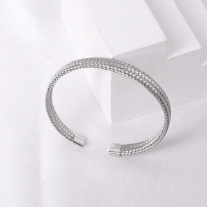 Macro detail of silver woven mesh texture on stainless steel open cuff bracelet