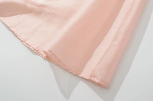 Close-up of the stitching and breathable fabric texture on a pink sleeveless dress