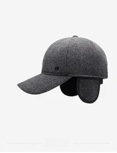 Detail of dark grey wool winter baseball cap showing foldable ear flaps and metal logo