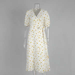 Détail d'une robe portefeuille à col en V avec imprimé fleuri jaune et manches bouffantes