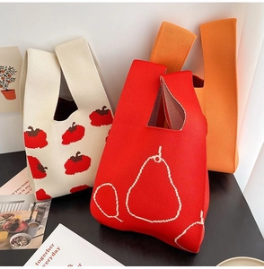 Detailed view of thick knitted tote bags featuring red apple and white pear patterns