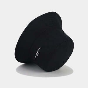 Black canvas bucket hat with white 'whatever' embroidery on a clean grey background
