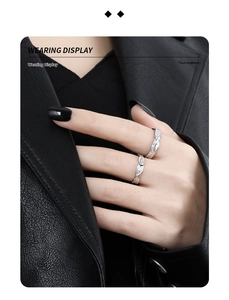 Wearing display of irregular textured silver rings on fingers against a leather jacket