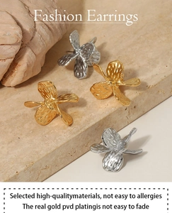 Detail of PVD gold plated flower earrings with anti-allergy material and hammered texture