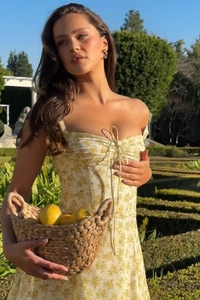 Detail of yellow floral dress featuring a square neckline with tie-up ribbon bow detail