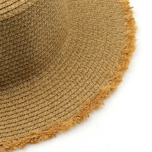 Close-up of a raffia straw hat showing the detailed weave texture and frayed edge finish