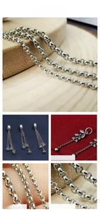 Macro detail of silver leaf pendant and rolled link chain in stainless steel finish
