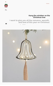 Close-up of golden hollow metal Christmas bell ornament with tree motif and beige tassel