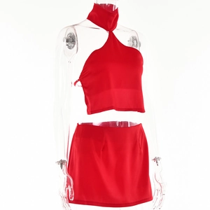 Detail of red halter backless crop top and mini skirt set with smooth fabric on mannequin