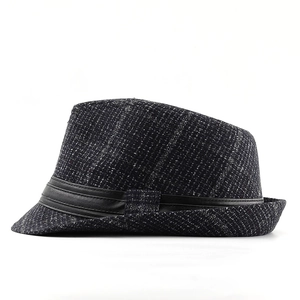 Macro shot of dark textured fedora wool felt with black faux leather hatband detail
