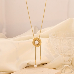 Macro detail of gold flower long tassel necklace with sunburst pearl pendant on silk