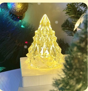 Close-up of a transparent glowing Christmas tree light with warm yellow LED illumination